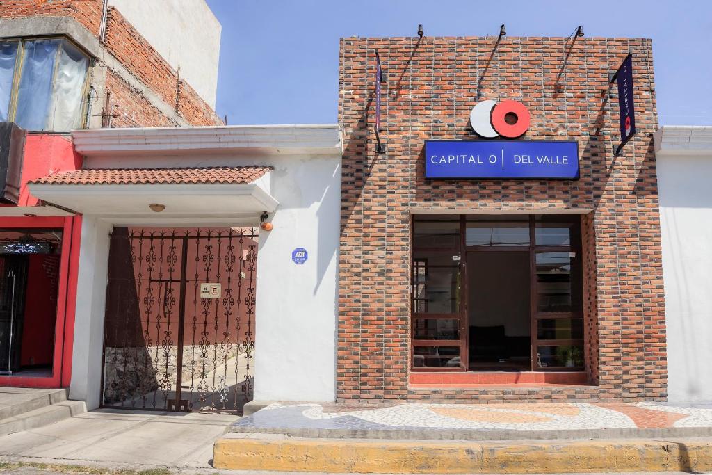 a brick building with a sign for a sushi restaurant at Capital O Del Valle, Tecamachalco in Tecamachalco