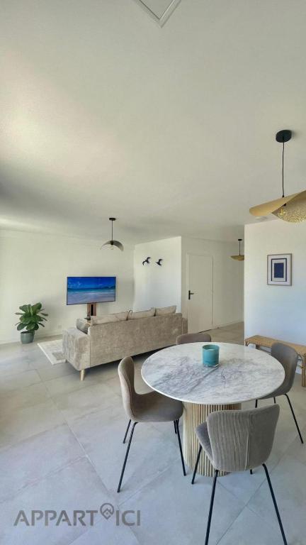 un salon avec une table et un canapé dans l'établissement APPART'ICI 3 - Spacieux appartement F3, à Lunel-Viel
