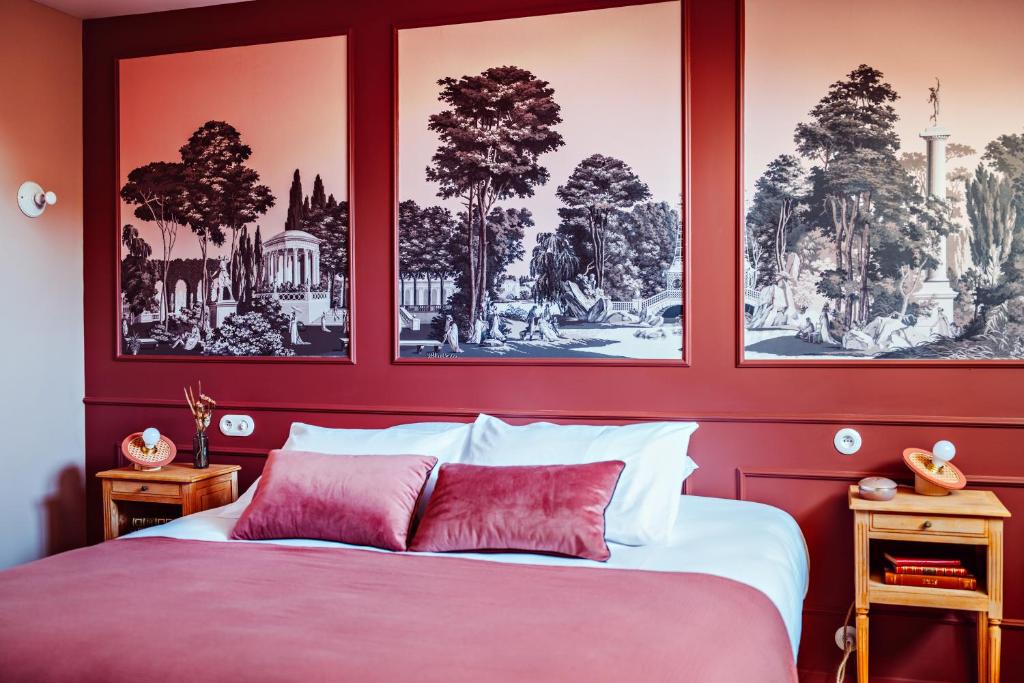 - une chambre dotée d'un mur rouge avec des photos au-dessus d'un lit dans l'établissement Hôtel Maison Lacassagne Lyon, à Lyon