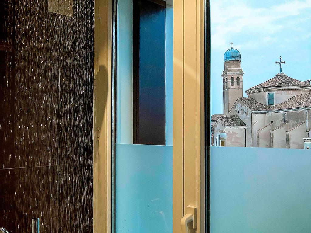a window view of a building with a church at Hotel Papadopoli Venezia - MGallery Collection in Venice