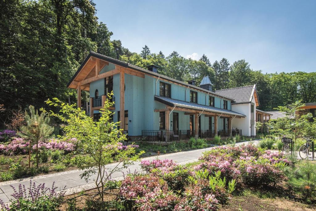 a house in the middle of a garden with flowers at Boutique Hotel Beekhuizen in Velp