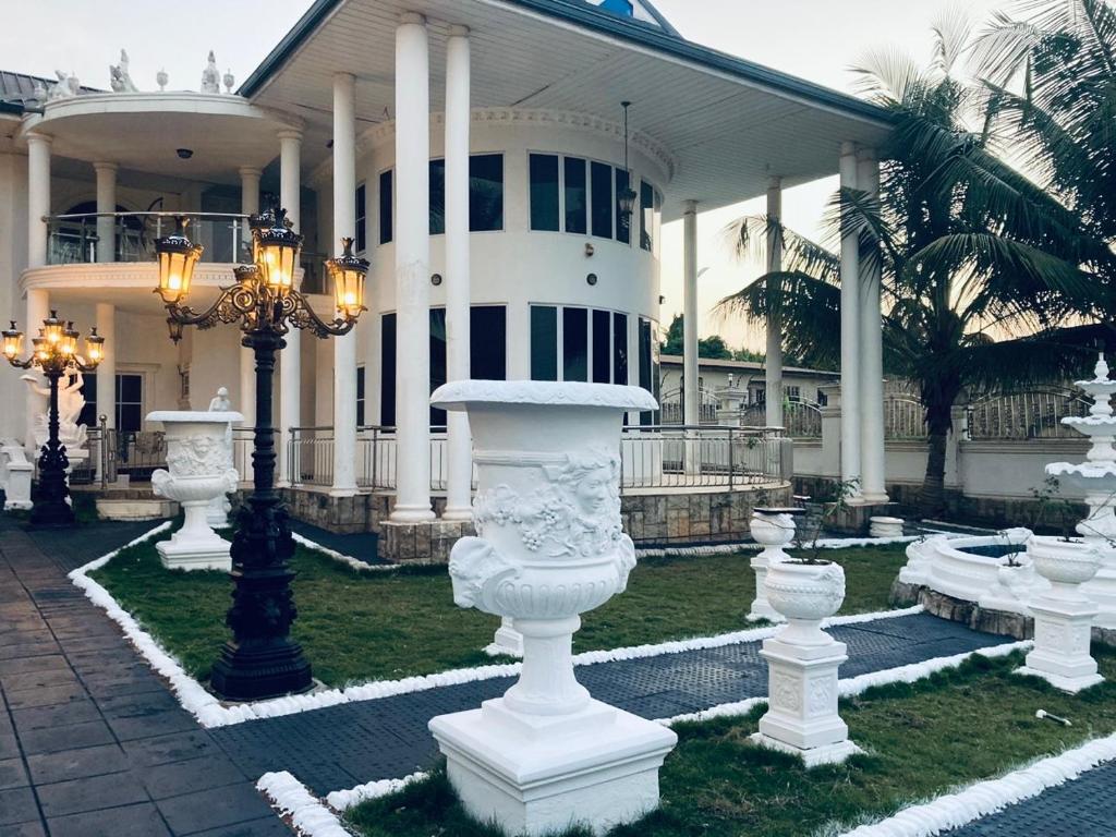 a large building with white statues in front of it at The Peacock Mansion in Kumasi