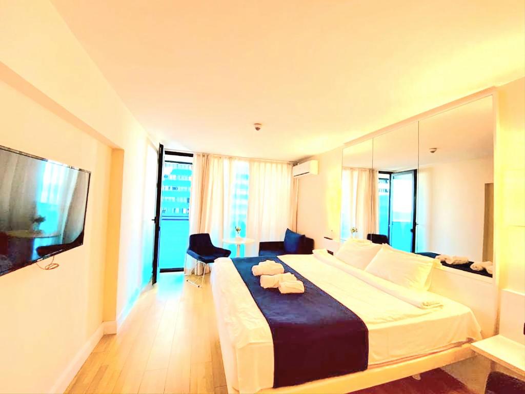 um quarto de hotel com uma cama grande e uma televisão de ecrã plano em ORBI CITY sea em Batumi