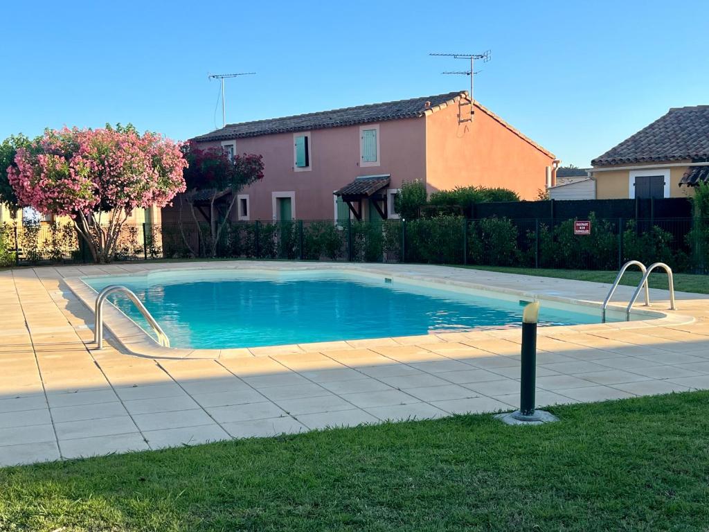 een zwembad in een tuin naast een huis bij Idéal pour vos vacances a in Aigues-Mortes