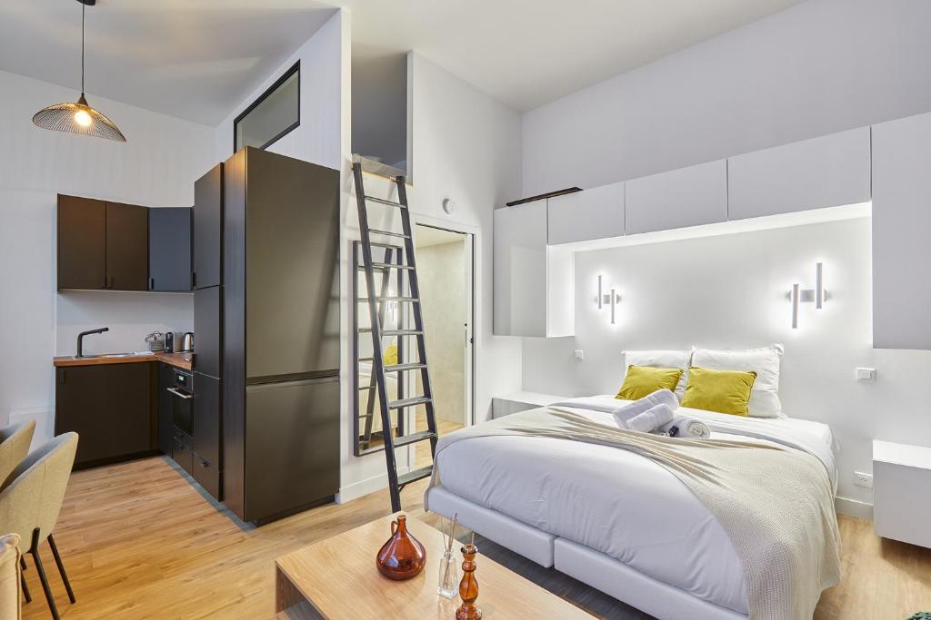 - une chambre avec une échelle à côté d'un lit dans l'établissement Studio Jardin du Luxembourg by Studio prestige, à Paris
