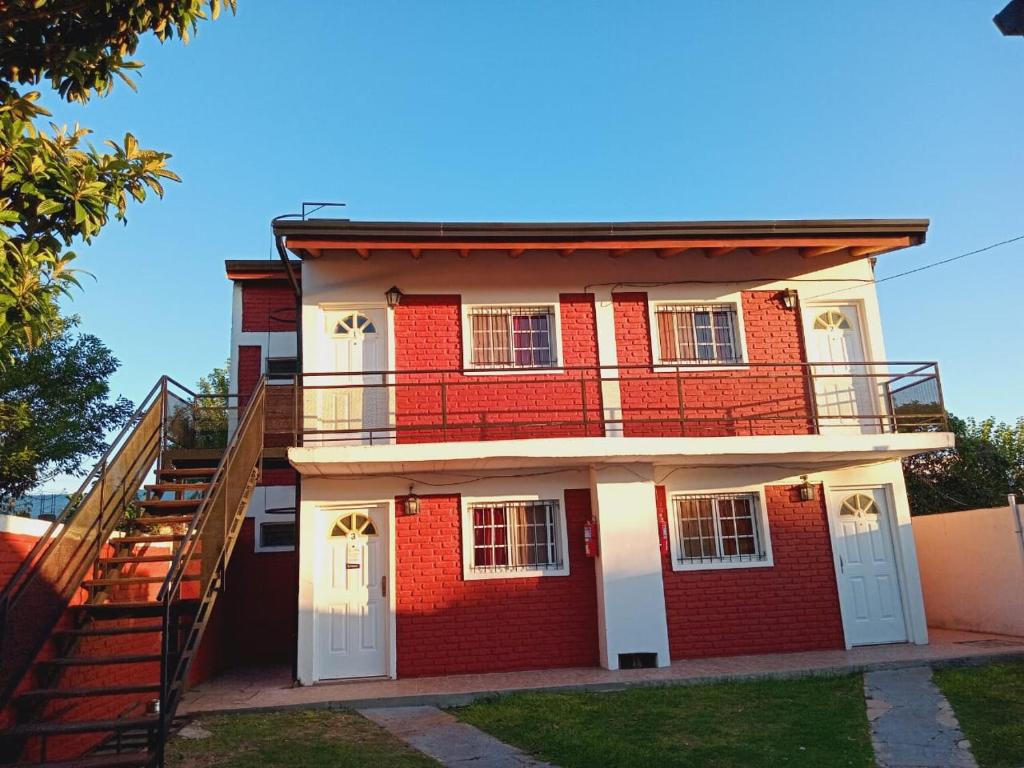 a red brick building with a staircase in front at Hospedaje BAHUINIAS II in Federación