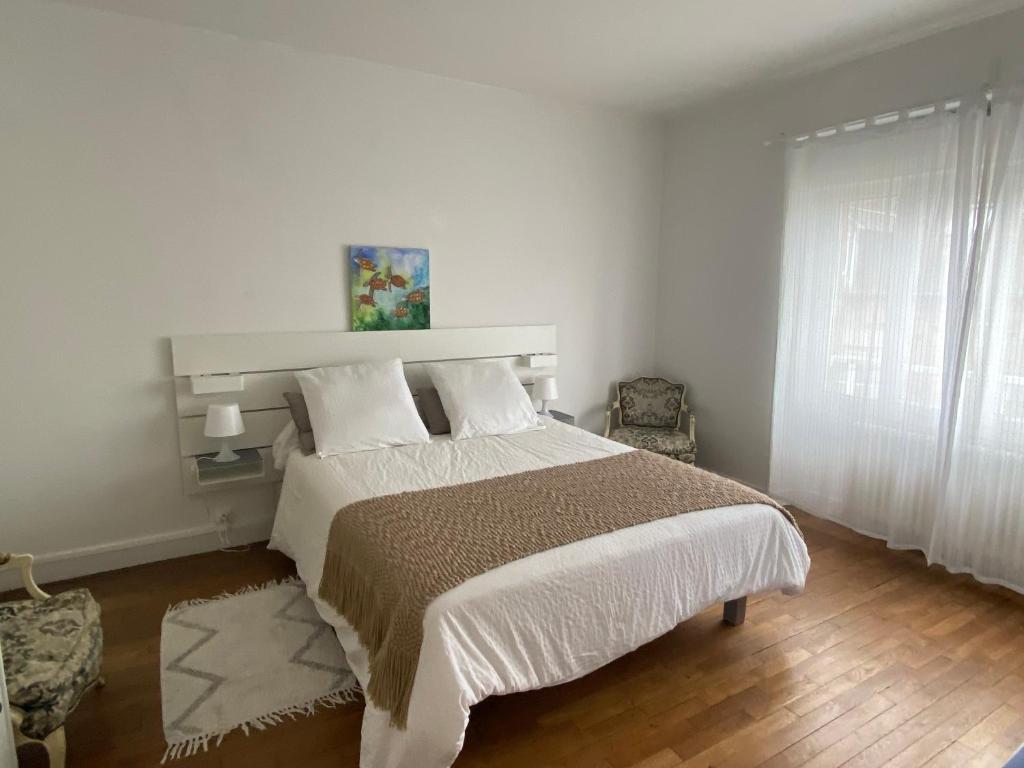 a bedroom with a large bed and a window at AQUARELLE in Avranches