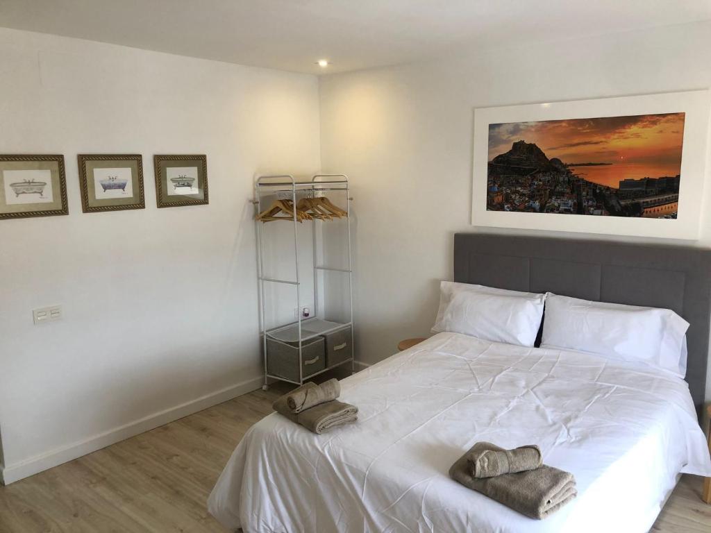 une chambre avec un lit blanc avec des serviettes dessus dans l'établissement Incredible Apartment, à Alicante
