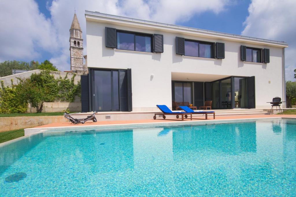 a villa with a swimming pool in front of a house at Modern Villa Anna with outdoor pool in Visnjan in Višnjan