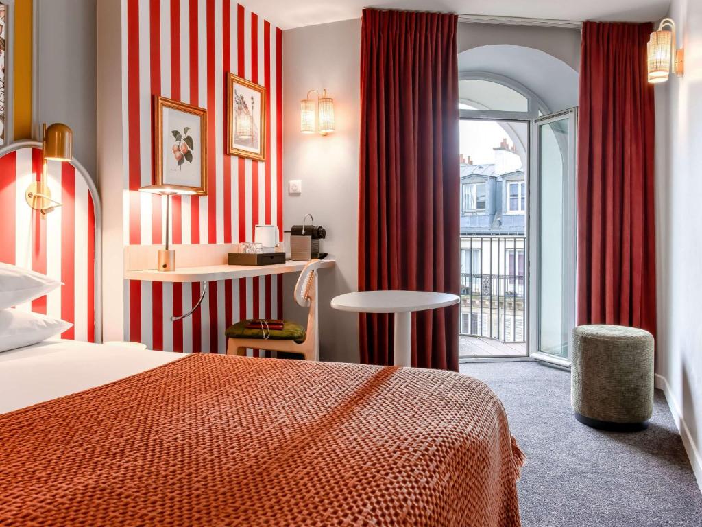 パリにあるメルキュール パリ ノートル ダム サン ジェルマン デ プレのベッドとバルコニー付きのホテルルーム