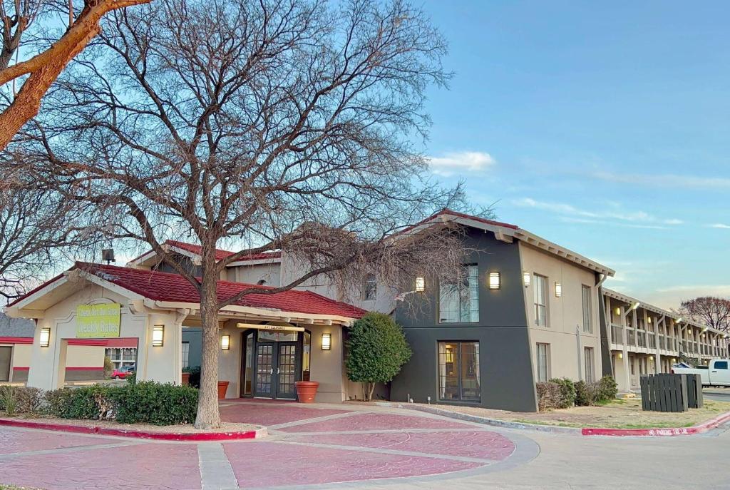 ein Gebäude mit einem Baum in der Mitte einer Straße in der Unterkunft La Quinta Inn by Wyndham Amarillo Mid-City in Amarillo