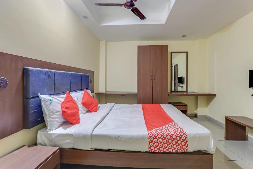 a bedroom with a large bed with red pillows at OYO Flagship Golden Manor in Chennai