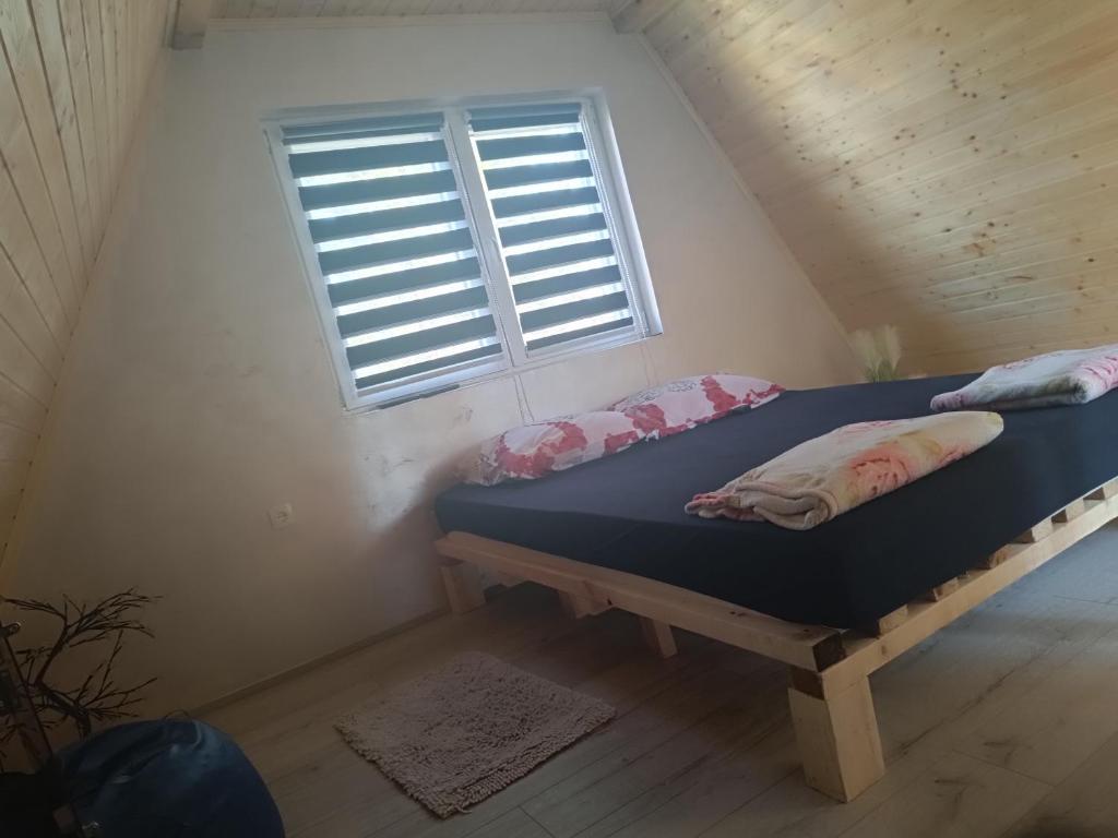 a bed in a room with a window at Vikendica Kelebija in Subotica
