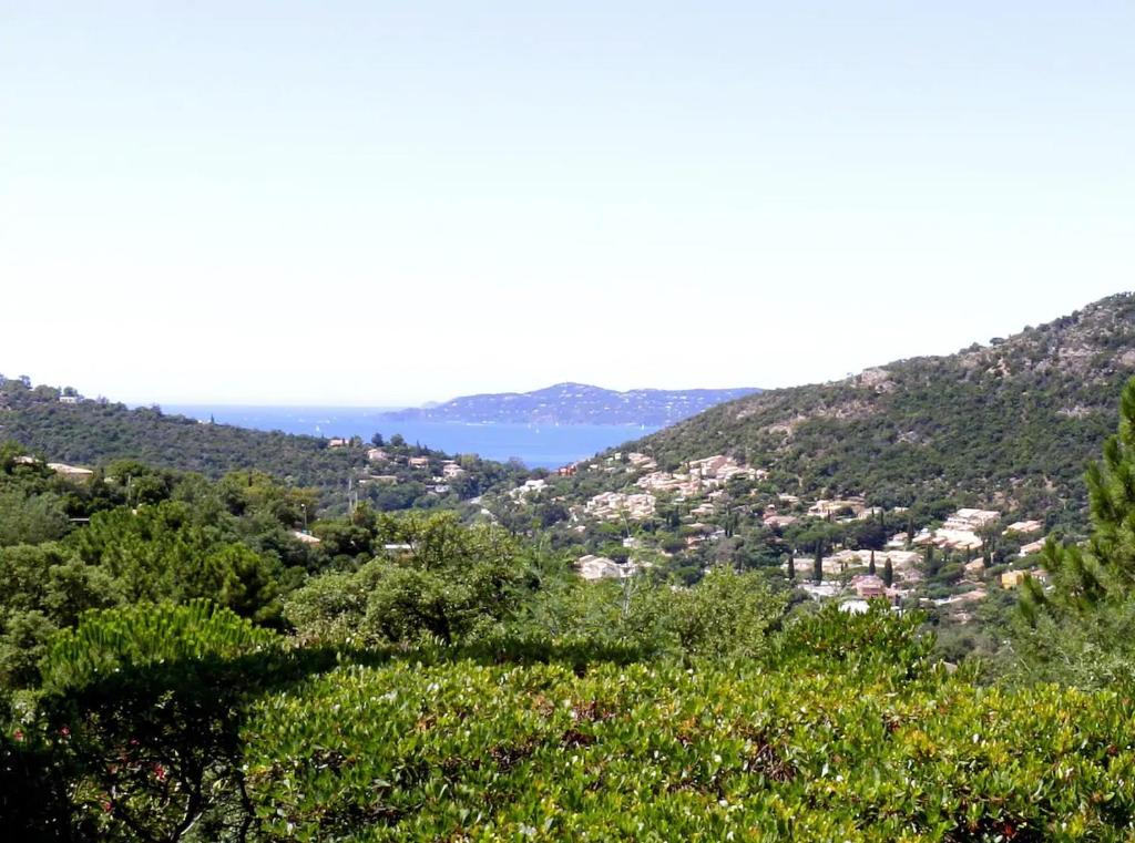 - une vue sur une vallée avec des arbres et une étendue d'eau dans l'établissement Chambre d'hôtes vue sur mer accés indépendant, à Rayol-Canadel-sur-Mer