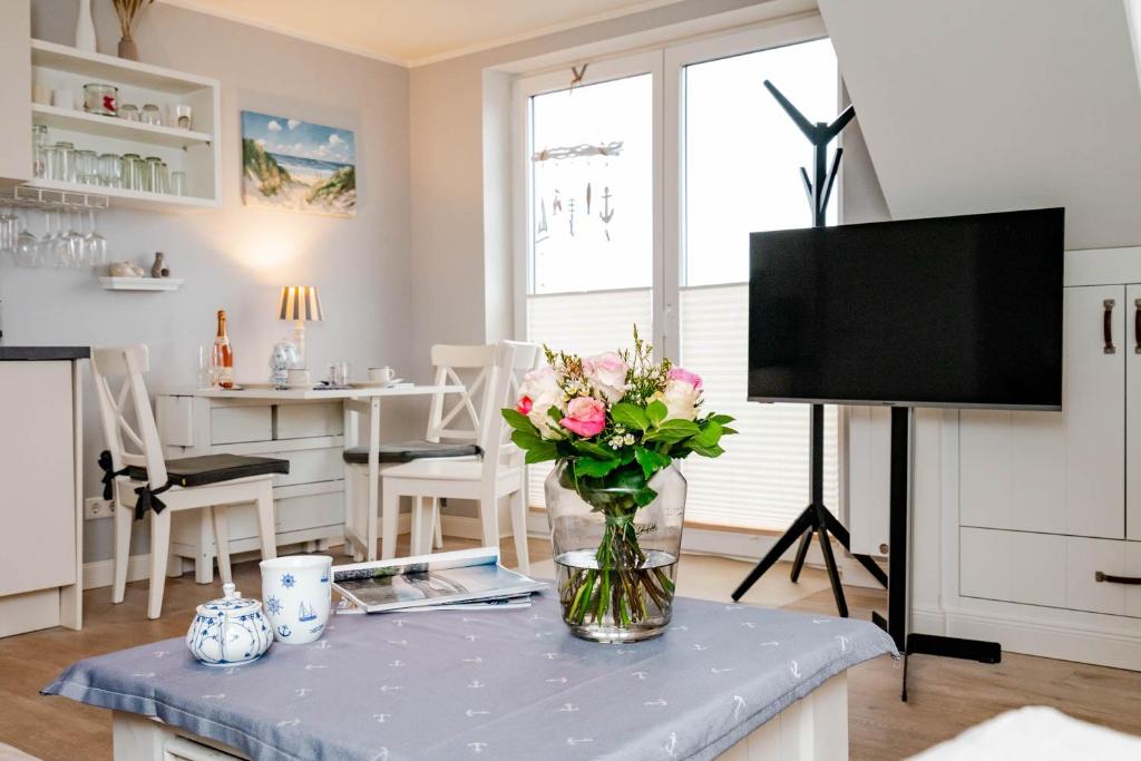 ein Wohnzimmer mit einer Blumenvase auf dem Tisch in der Unterkunft Kleine Buhne in Wenningstedt-Braderup