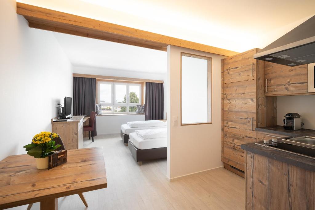 een kamer met een keuken en een woonkamer bij Snooze Apartments in Holzkirchen