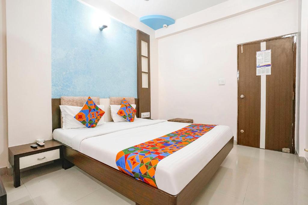 a bedroom with a bed with a colorful blanket on it at FabHotel Skylon, Near Mahatma Mandir in Pethāpur