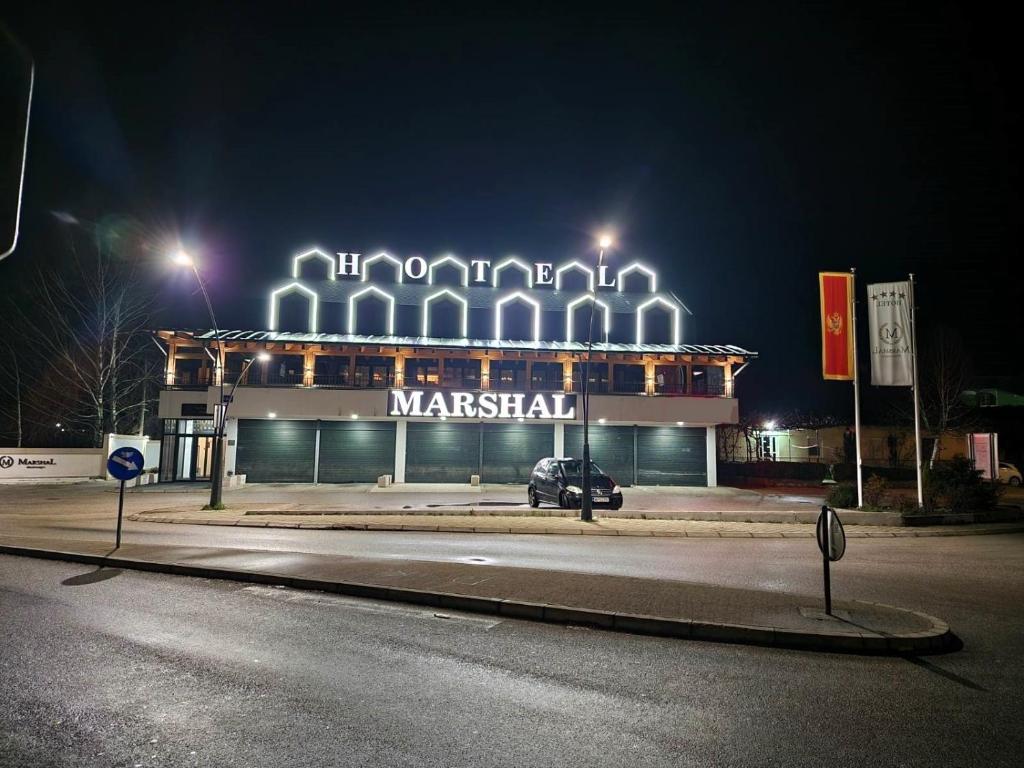 a building with a car parked in front of it at night at Hotel Marshal in Nikšić