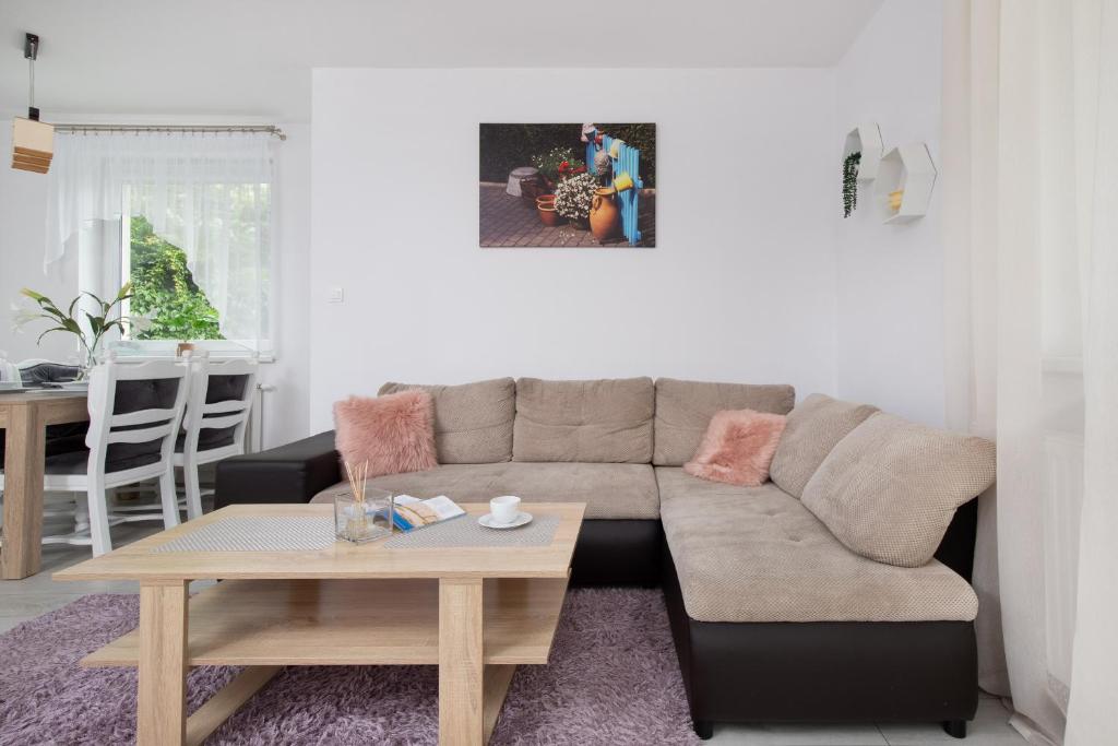 a living room with a couch and a table at Elegant Apartment Myśliwskie Wzgórze in Gdańsk by Renters in Gdańsk