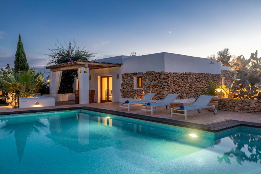 a villa with a swimming pool at night at Can White in Sant Carles de Peralta