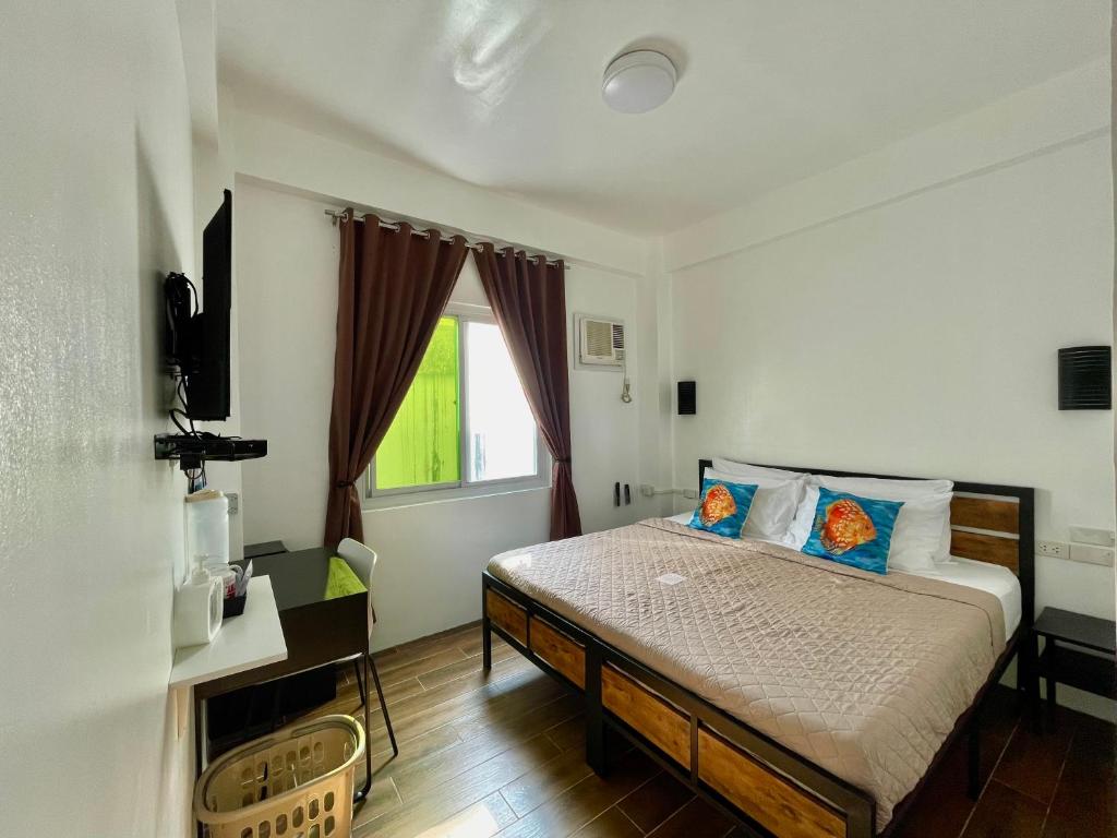sypialnia z łóżkiem i oknem w obiekcie Arkipelago Beach Resort w mieście Puerto Galera
