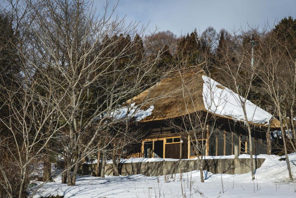 a house with snow on the roof and trees at awai 戸隠 in Nagano