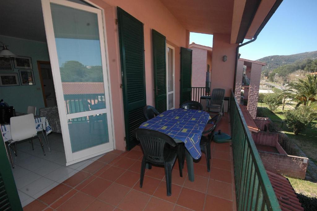 patio ze stołem i krzesłami na balkonie w obiekcie Acquacheta w mieście Marina di Campo