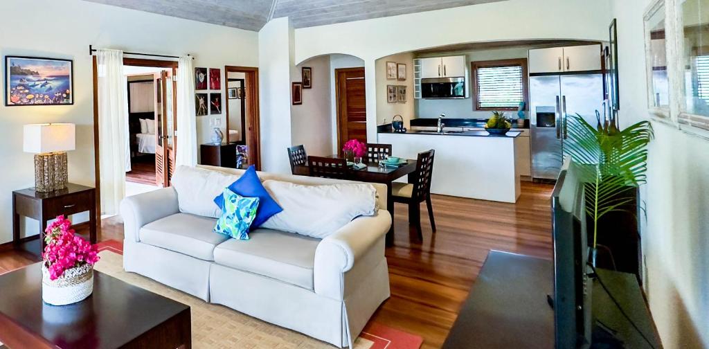 een woonkamer met een witte bank en een keuken bij The Hideaway Suite 1512 Pool and Sea views in Gaynors