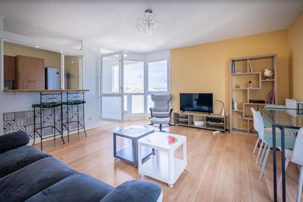ein Wohnzimmer mit einem Sofa und einem Tisch in der Unterkunft L'Horizon, T3, Terrasse, Pkg, Quartier Antigone in Montpellier