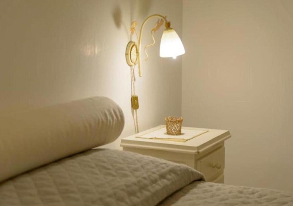 ein Schlafzimmer mit einem Bett und einem Tisch mit einer Lampe in der Unterkunft Trullo U Selvese in Alberobello