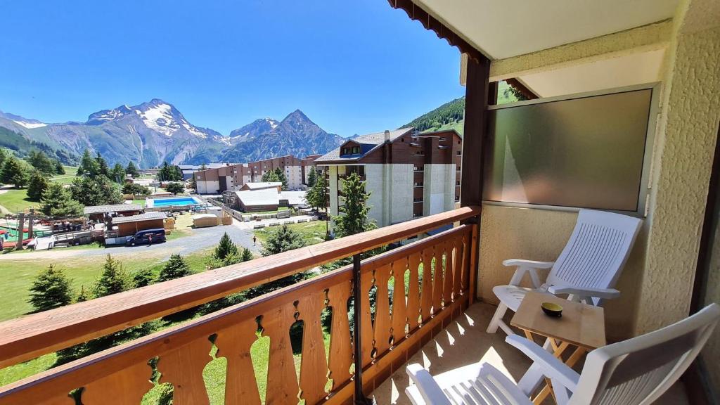 d'un balcon avec deux chaises et une vue sur les montagnes. dans l'établissement Gioberney - 17 - Studio bord de piste - 4 pers, à Les Deux Alpes