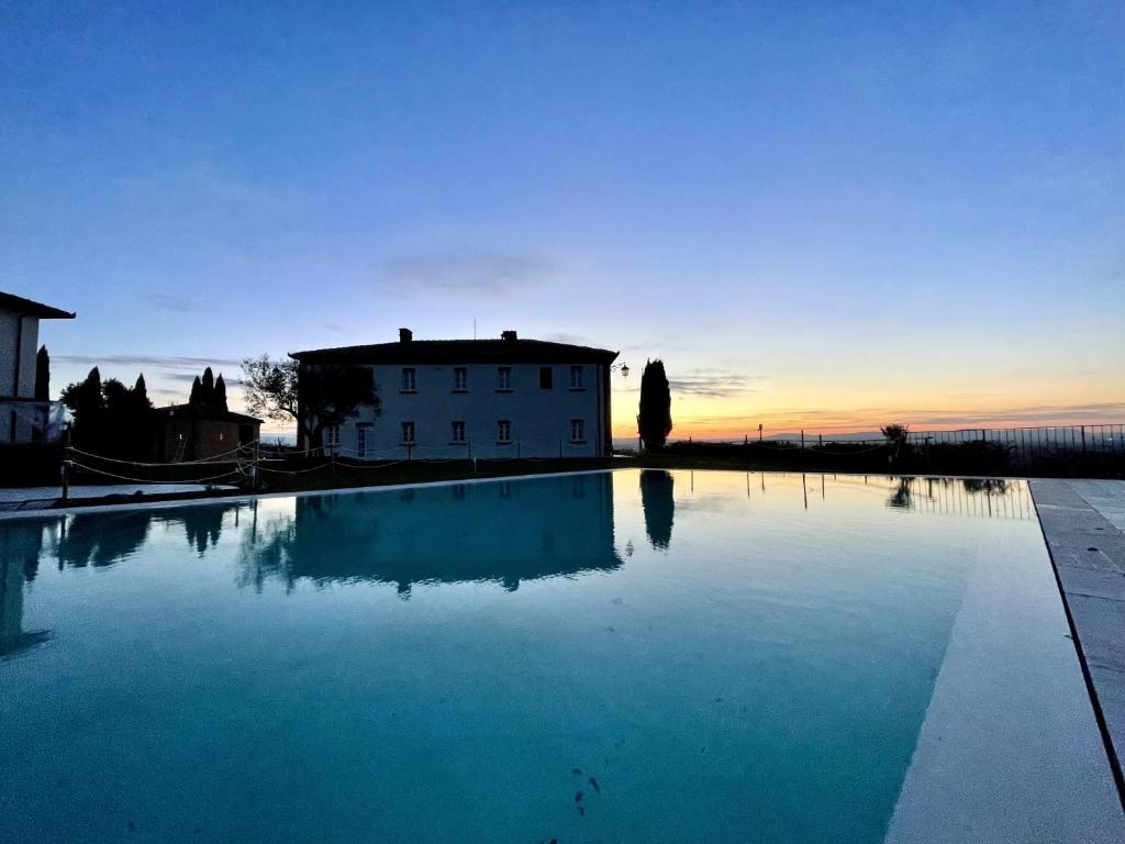 a large swimming pool in front of a house at Villa ideale per riunioni familiari nella pace della campagna cortonese in Valiano