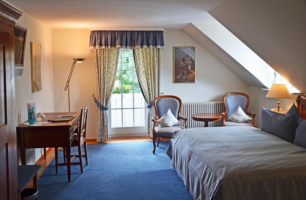 um quarto com uma cama, uma secretária e uma janela em Hotel Mühle em Binzen