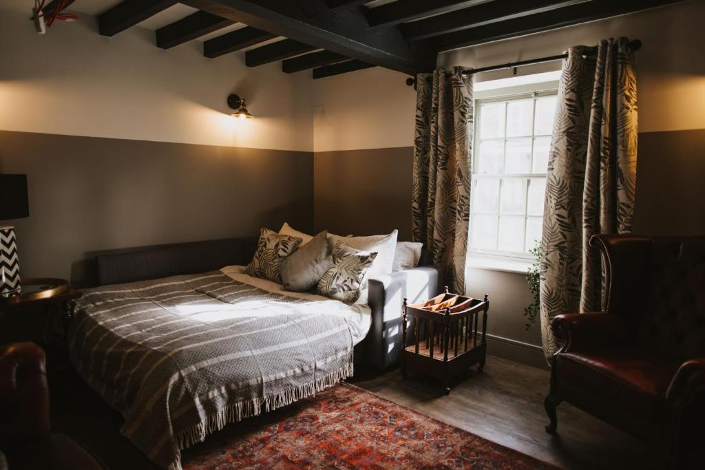Schlafzimmer mit einem Bett und einem Fenster in der Unterkunft The White Hart in Brigg