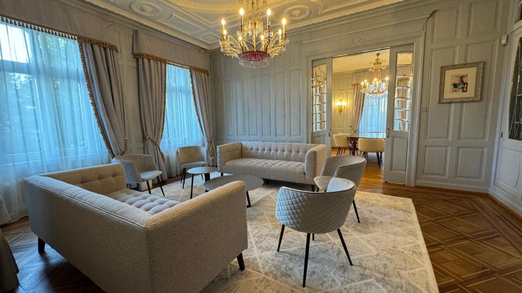 una sala de estar con sofás, sillas y una lámpara de araña. en Entire Zurich Villa, Your Private Luxury Escape en Zúrich