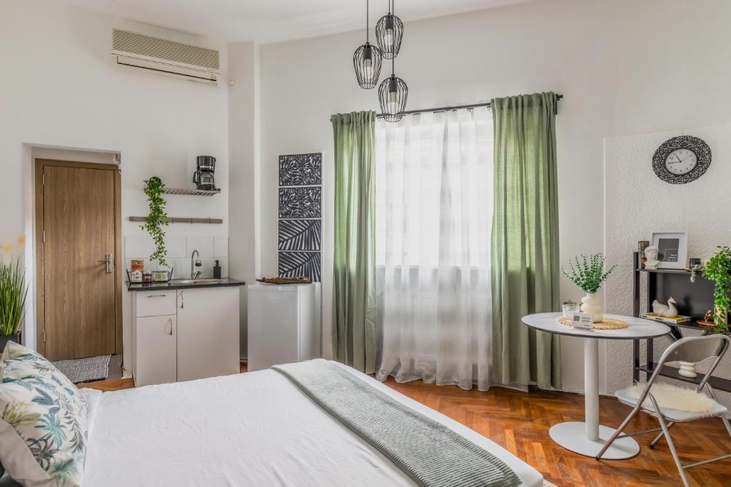 Un dormitorio con una cama y una mesa y una cocina. en Nightfall Escape - M&N Condos, en Bucarest