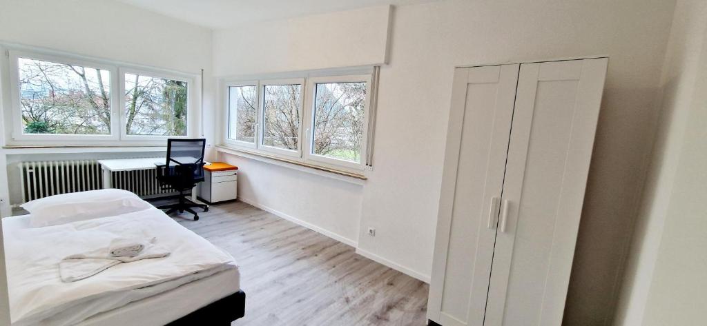 Habitación blanca con 1 cama y 2 ventanas en EFDE GmbH- Studenten und Business WG-Zimmer ab sofort frei 3-er WG inkl. Reinigungservice, en Heilbronn