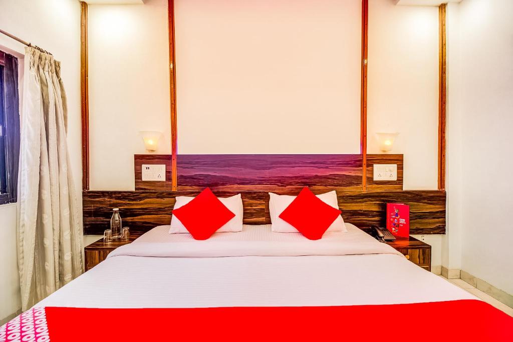 1 dormitorio con 1 cama grande con almohadas rojas en Super Collection O Hotel Panchratna, en Panvel