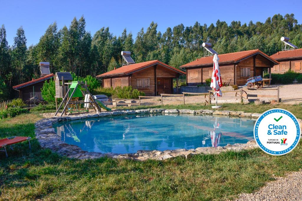 uma piscina em frente a um chalé de madeira em Quintinha do Casal Ruivo em Figueiró dos Vinhos