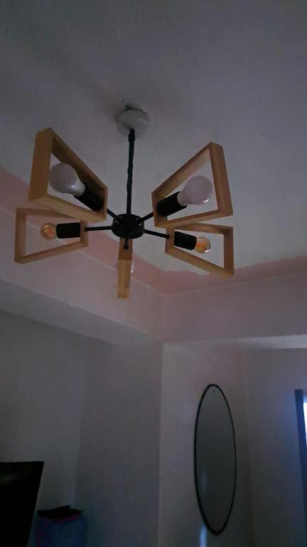 a ceiling fan with two lights and a mirror at L&A Homes in Kisii