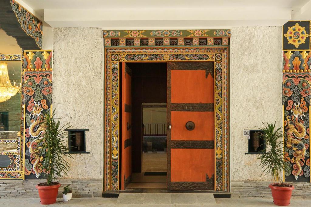 uma entrada para um edifício com uma porta laranja em Kaachi Grand Hotel em Paro