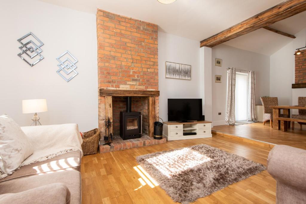 a living room with a fireplace and a tv at Ashtree Farm in Durham