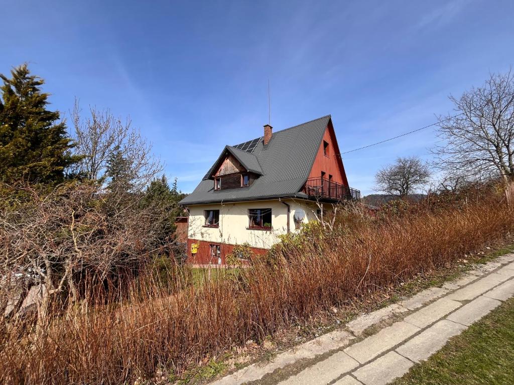 uma casa vermelha e branca sentada no topo de uma colina em Agroturystyka Skałka em Wisła