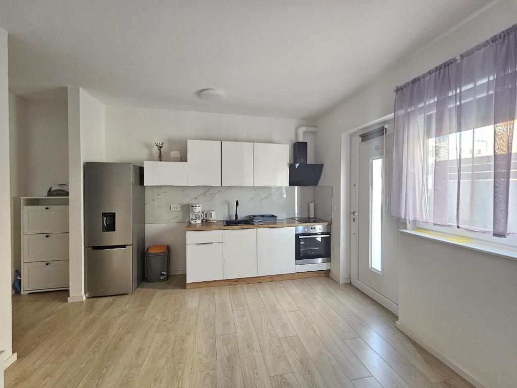 uma cozinha com armários brancos e uma bancada em Apartments Anamarija em Zadar