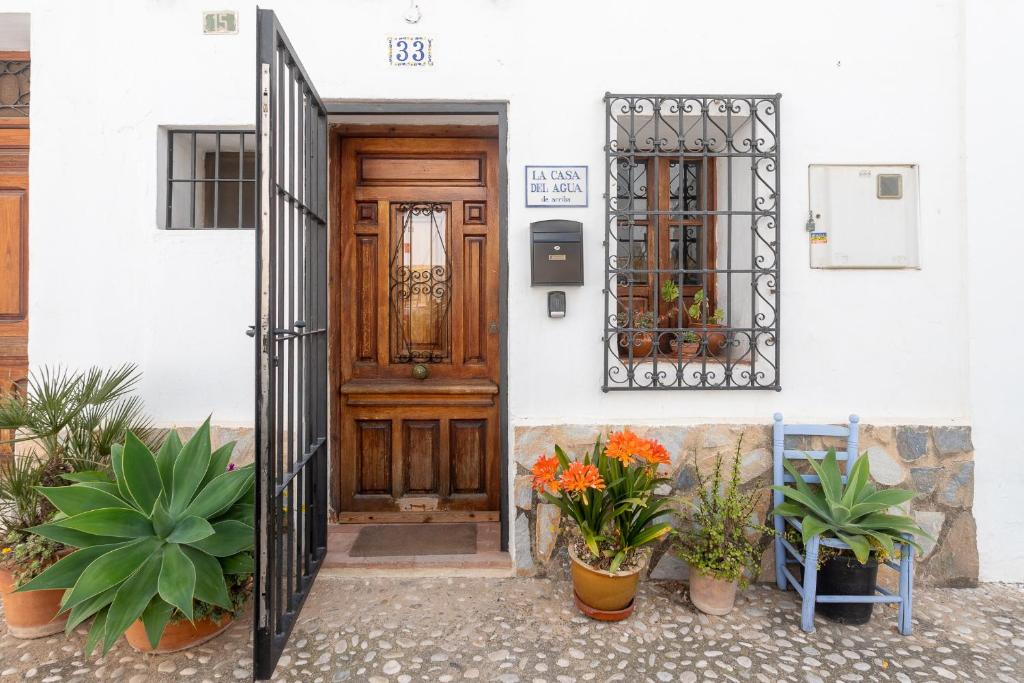 阿爾啼的住宿－La Casa del Agua，前方有盆栽植物的房子的门