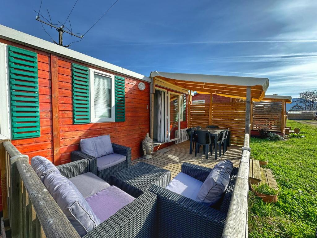 Casa con terraza con mesa y sillas en Grand Mobile-Home 6 Places climatisé en Munster