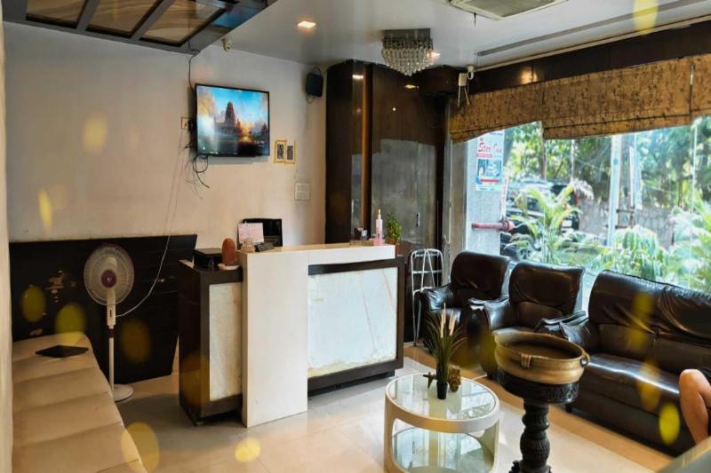 ein Wohnzimmer mit einem Sofa und einem TV in der Unterkunft Ira Star Inn in Hyderabad