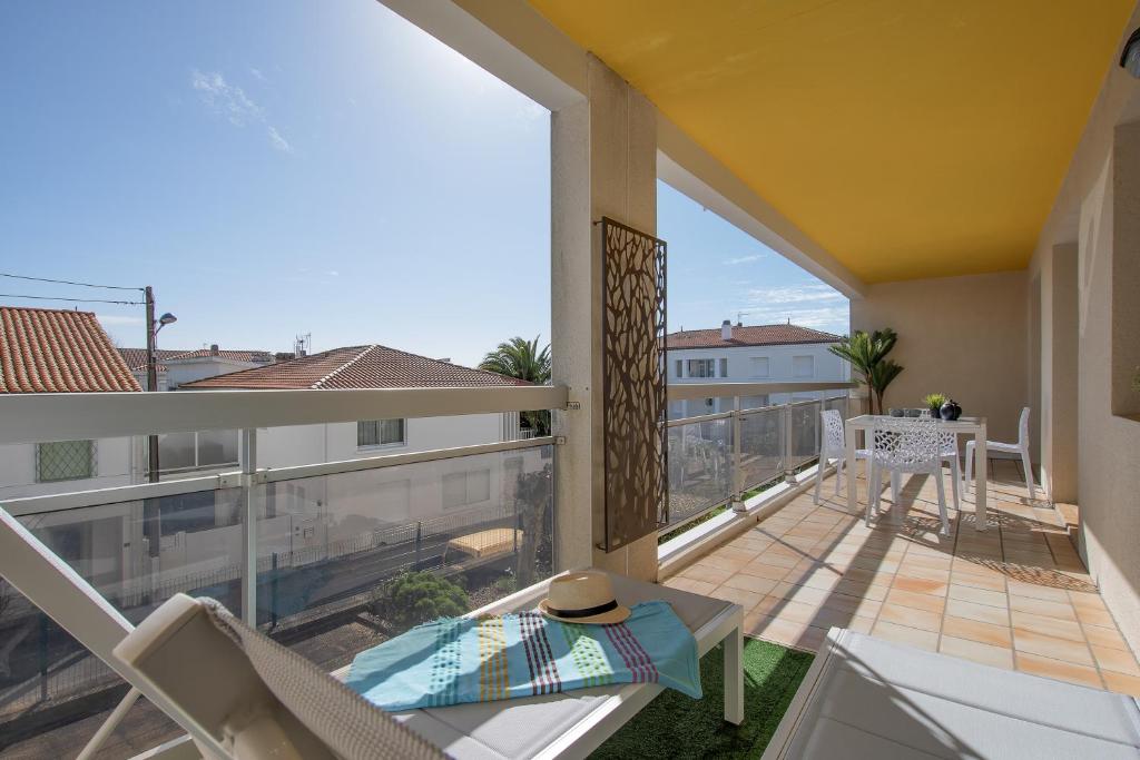 un balcon avec une table et des chaises sur un balcon dans l'établissement Le Sable Fin - Appt à 300m de la plage, à Royan