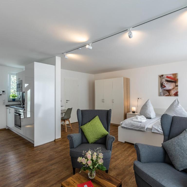 1 dormitorio y sala de estar con 1 cama y sillas en IMMOCITY Apartments Ost en Darmstadt