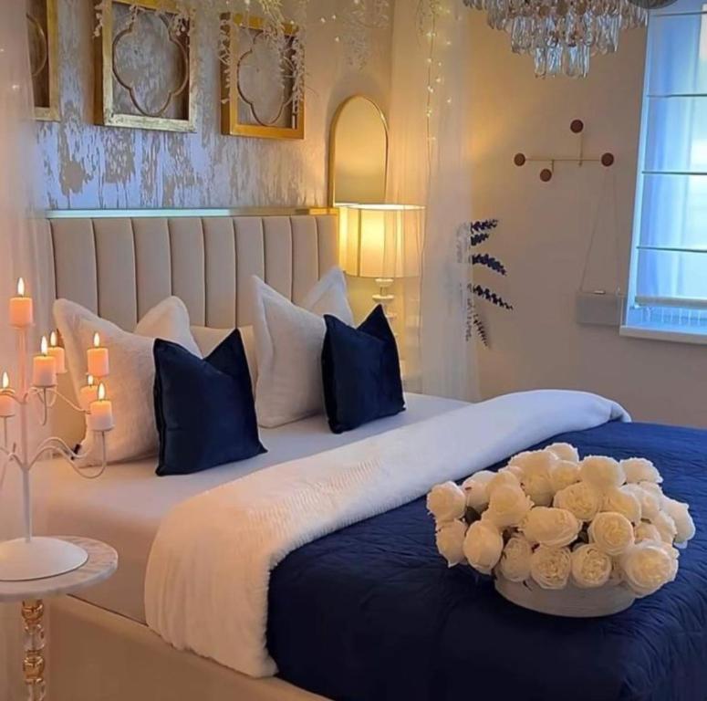 1 dormitorio con 1 cama grande con almohadas azules y blancas en فندق السعاده, en ‘Izbat Hud.hud